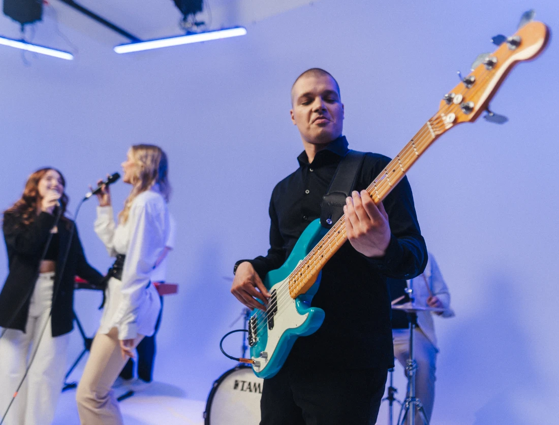 Bassist suures plaanis, lauljad tagaplaanil